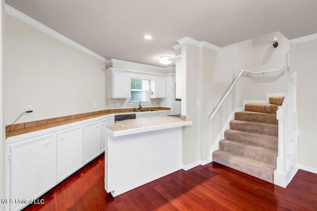 kitchen featuring crown molding, white cabinetry, dark wood finished floors, a peninsula, and a sink