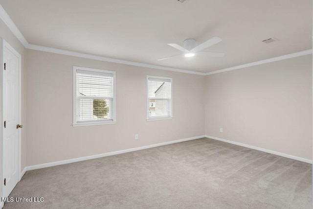 carpeted spare room with ceiling fan, crown molding, and baseboards