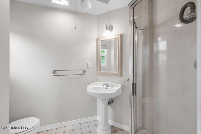 full bathroom with a shower stall, a ceiling fan, toilet, and baseboards