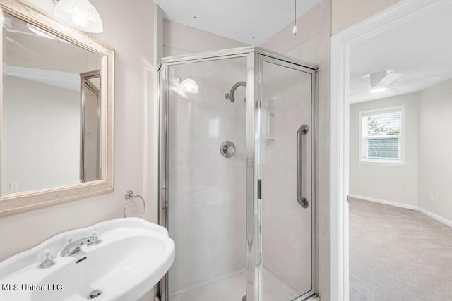 full bath with a sink, a shower stall, and baseboards