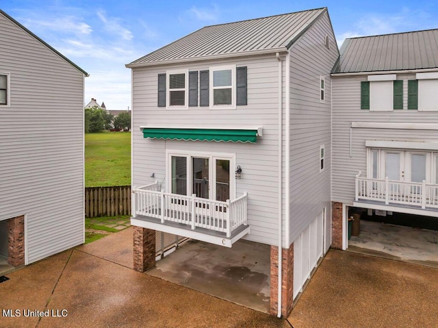 rear view of house featuring metal roof and a standing seam roof