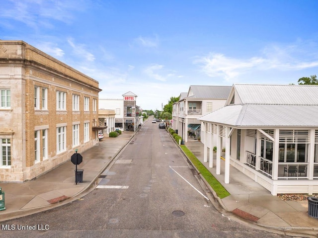 view of asphalt street with curbs and sidewalks
