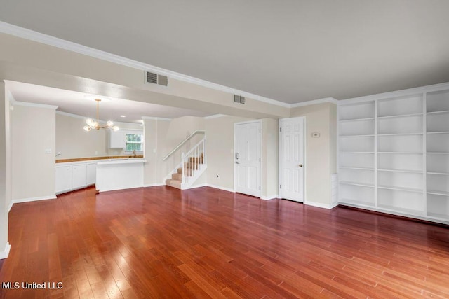 unfurnished living room with a chandelier, wood finished floors, stairs, baseboards, and built in shelves