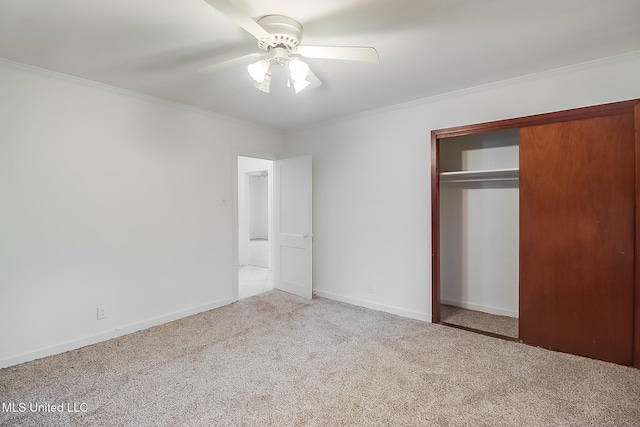 unfurnished bedroom with ceiling fan, light colored carpet, ornamental molding, and a closet