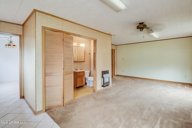 unfurnished living room featuring light carpet, sink, heating unit, and ornamental molding