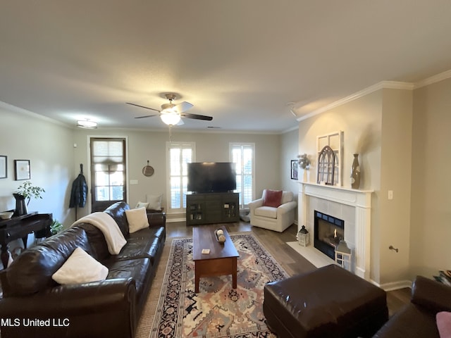 living room featuring crown molding, a tiled fireplace, and hardwood / wood-style floors