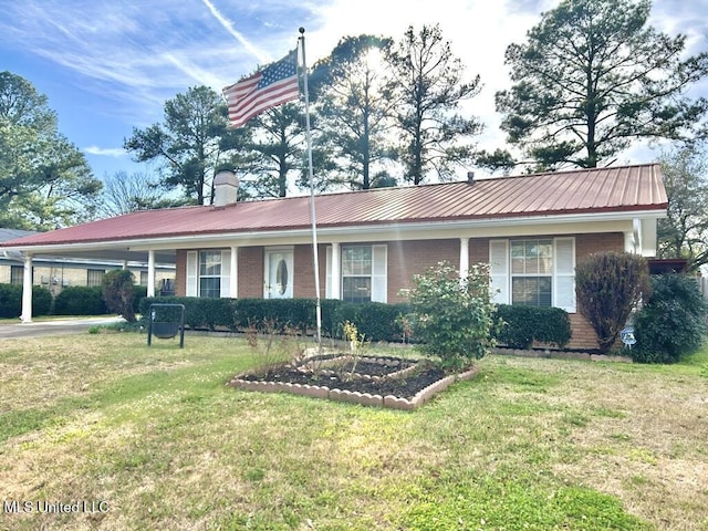 ranch-style house with metal roof, brick siding, a chimney, and a front lawn