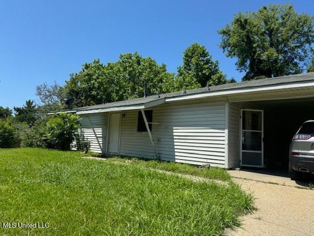 205 Hillside Dr, Vicksburg, MS 39180 - view of side of home featuring an attached carport and a lawn
