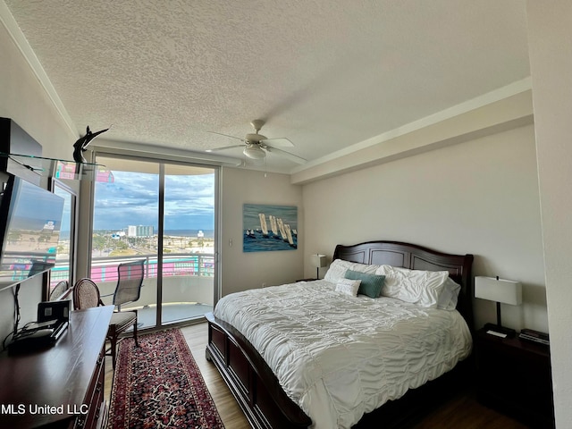 bedroom with a textured ceiling, ceiling fan, access to exterior, and dark hardwood / wood-style flooring