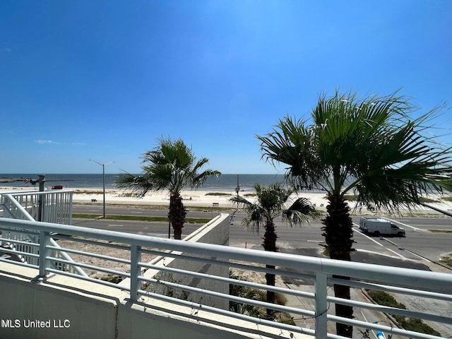 balcony featuring a water view and a beach view