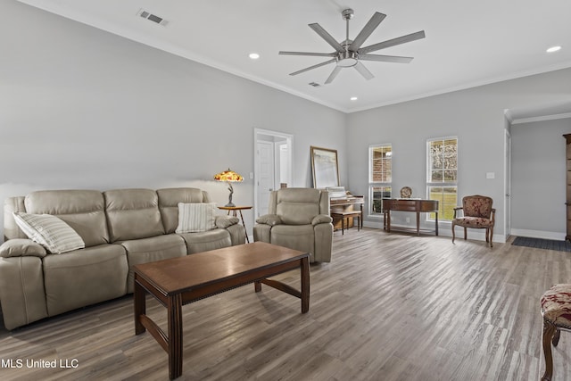 living area featuring baseboards, visible vents, ornamental molding, wood finished floors, and recessed lighting