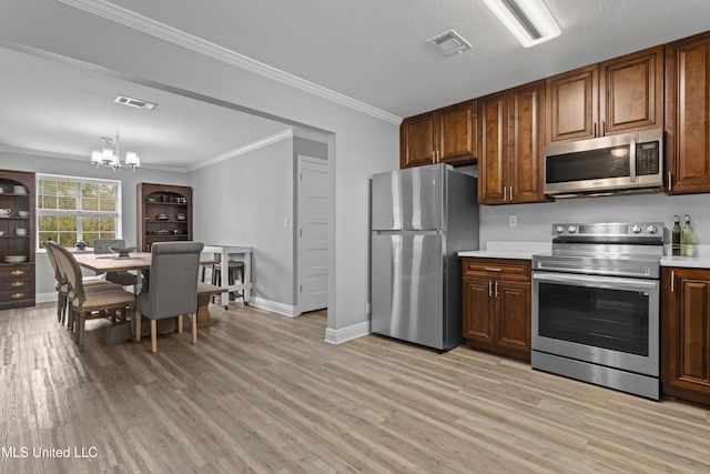 kitchen with stainless steel appliances, light wood-type flooring, light countertops, and visible vents