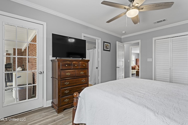 bedroom featuring a ceiling fan, visible vents, light wood-style floors, ornamental molding, and a closet