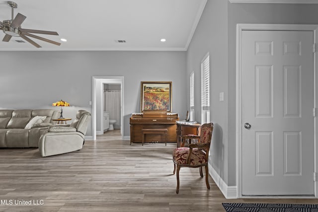 living area featuring baseboards, visible vents, ornamental molding, light wood-type flooring, and recessed lighting