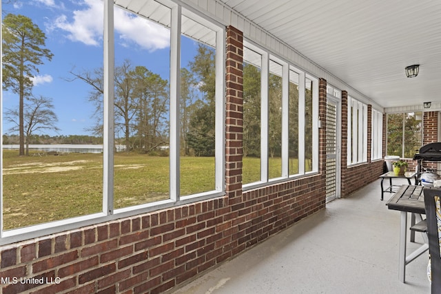 unfurnished sunroom with a water view