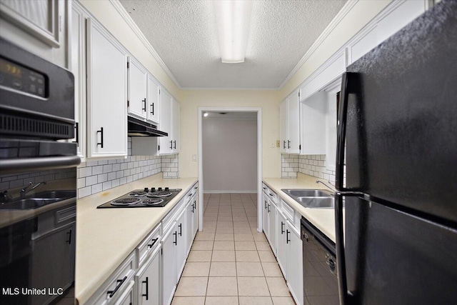 244 Massey Cir, Carthage, MS 39051 - kitchen featuring black appliances, under cabinet range hood, a textured ceiling, tasteful backsplash, and a sink