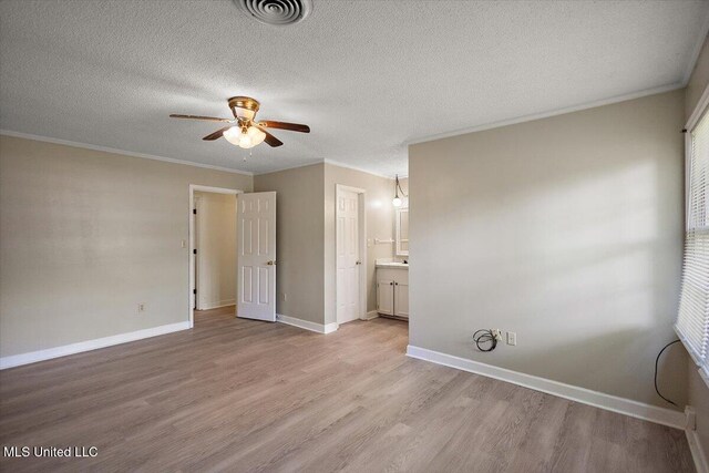 244 Massey Cir, Carthage, MS 39051 - unfurnished bedroom with light wood-style flooring, crown molding, a textured ceiling, connected bathroom, and baseboards