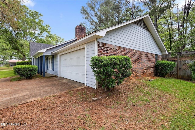 244 Massey Cir, Carthage, MS 39051 - view of home's exterior featuring brick siding, a chimney, a garage, and driveway
