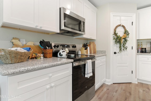 14172 Debra Barbee Ct, Gulfport, MS 39503 - kitchen with stainless steel appliances, light wood-style flooring, white cabinets, and light stone countertops