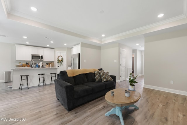 14172 Debra Barbee Ct, Gulfport, MS 39503 - living area with a tray ceiling, light wood finished floors, recessed lighting, baseboards, and ornamental molding