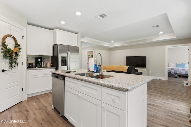 14172 Debra Barbee Ct, Gulfport, MS 39503 - kitchen featuring appliances with stainless steel finishes, a sink, recessed lighting, a tray ceiling, and light wood finished floors
