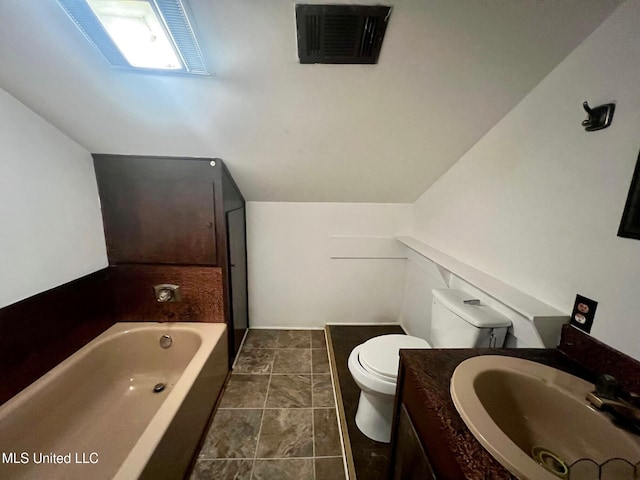 bathroom featuring vanity, lofted ceiling, a washtub, and toilet