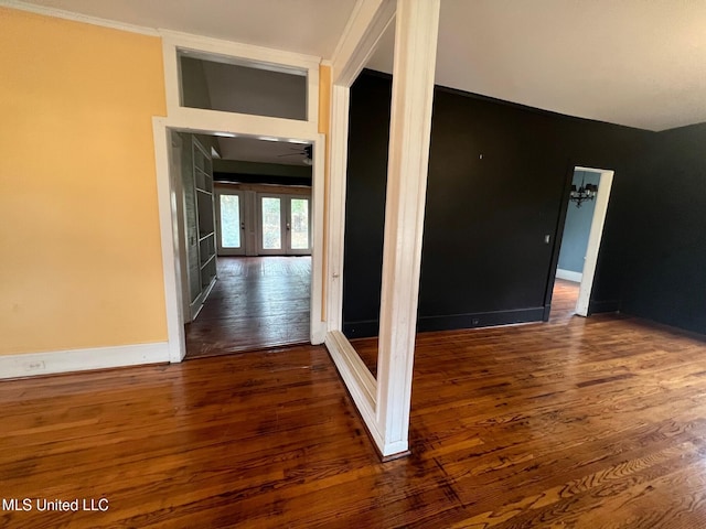 corridor featuring dark hardwood / wood-style flooring, crown molding, and french doors