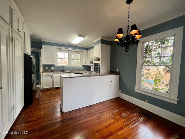 kitchen with crown molding, white cabinetry, hanging light fixtures, kitchen peninsula, and oven