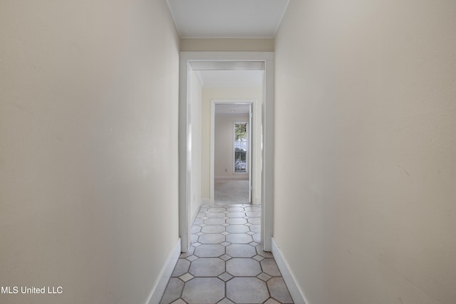 hallway featuring crown molding and baseboards