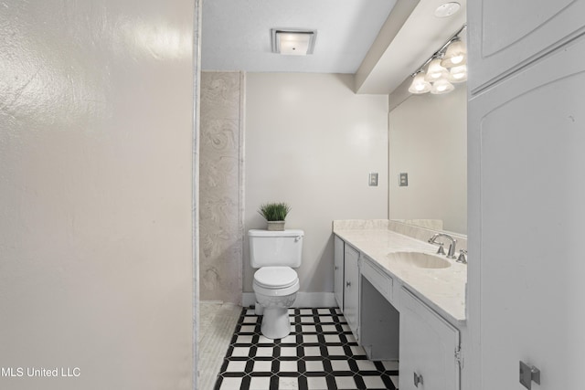 bathroom featuring baseboards, vanity, and toilet