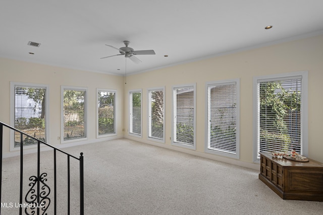 unfurnished sunroom featuring ceiling fan, visible vents, and a healthy amount of sunlight