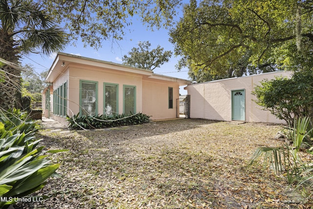 rear view of property featuring stucco siding