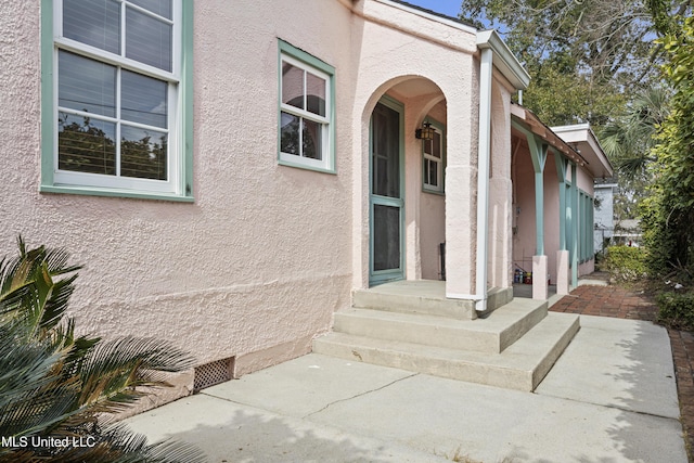 entrance to property featuring stucco siding