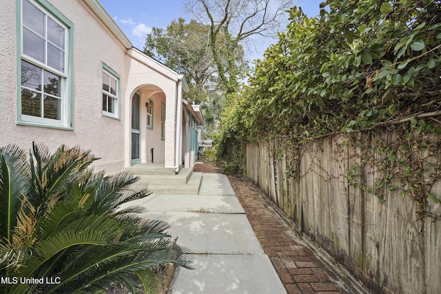 view of home's exterior with fence and stucco siding