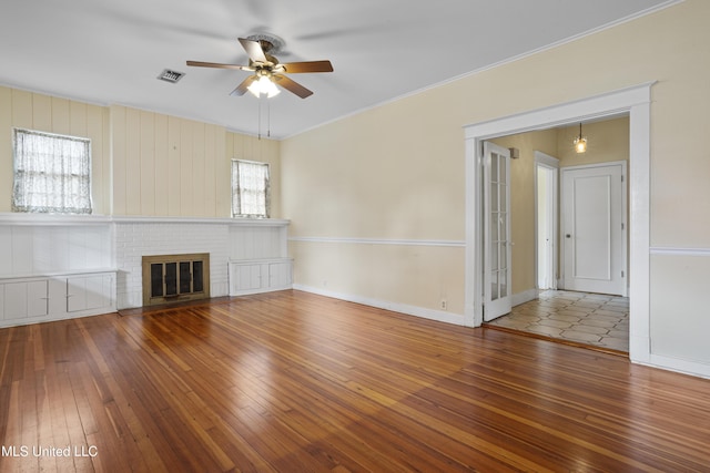 unfurnished living room with ceiling fan, wood-type flooring, a fireplace, and baseboards