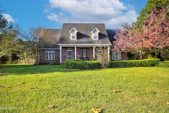 cape cod home with a front lawn