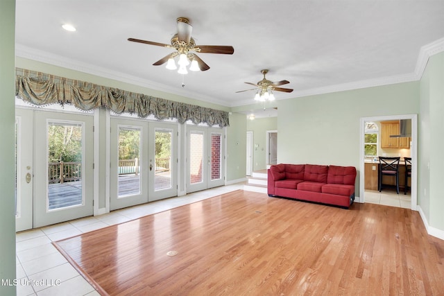 living room with french doors, light hardwood / wood-style flooring, ceiling fan, and ornamental molding