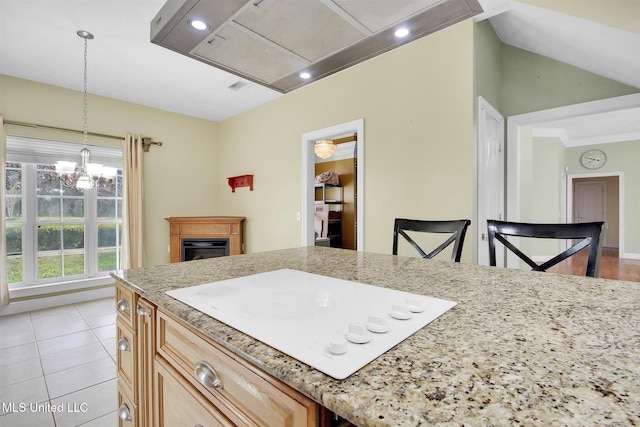 kitchen featuring white electric stovetop, a breakfast bar, decorative light fixtures, a chandelier, and light tile patterned flooring