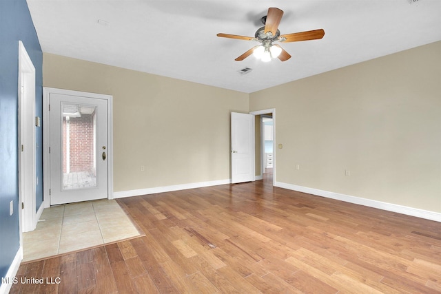 empty room with ceiling fan and light hardwood / wood-style flooring