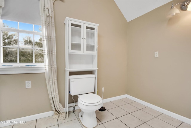 bathroom featuring tile patterned flooring, vaulted ceiling, and toilet