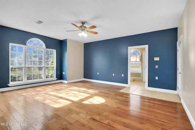 unfurnished room with light wood-type flooring, a baseboard radiator, and ceiling fan