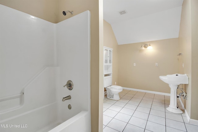 bathroom with tile patterned flooring, toilet, lofted ceiling, and shower / tub combination