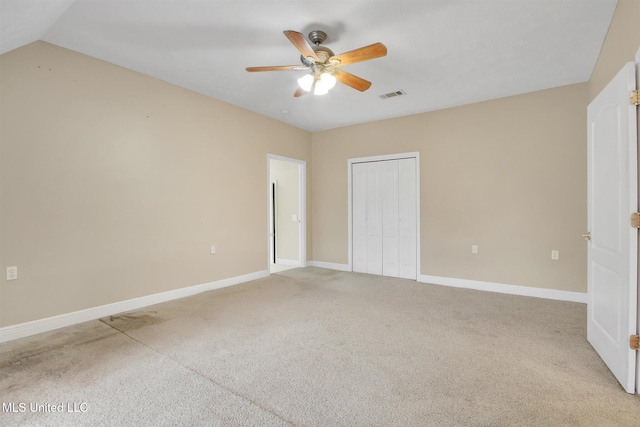 unfurnished bedroom with light carpet, a closet, ceiling fan, and lofted ceiling