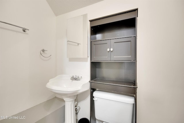 bathroom featuring a textured ceiling and toilet