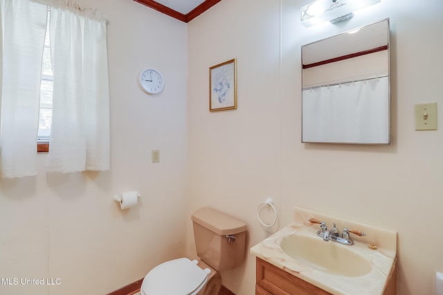 bathroom with crown molding, vanity, and toilet