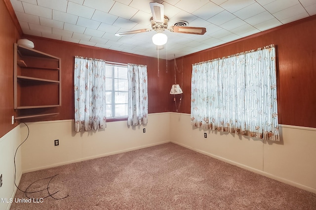 carpeted spare room with ceiling fan and ornamental molding