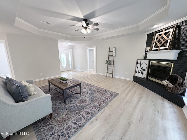 106 Ole Duke Dr, Brandon, MS 39042 - living room with a tray ceiling, a ceiling fan, a fireplace, ornamental molding, and wood finished floors