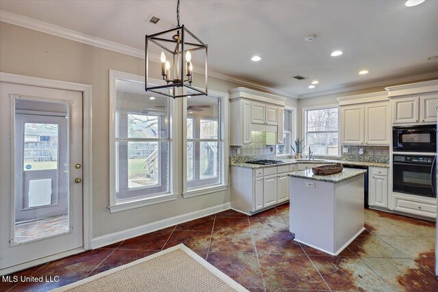 kitchen featuring a kitchen island, light stone countertops, black appliances, tasteful backsplash, and pendant lighting