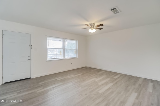 interior space with a ceiling fan, light wood-type flooring, visible vents, and baseboards