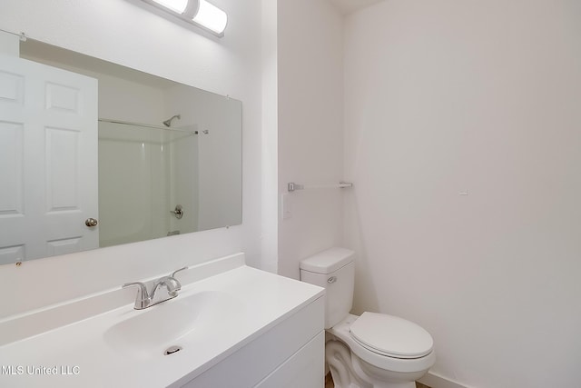 bathroom featuring a shower, vanity, and toilet